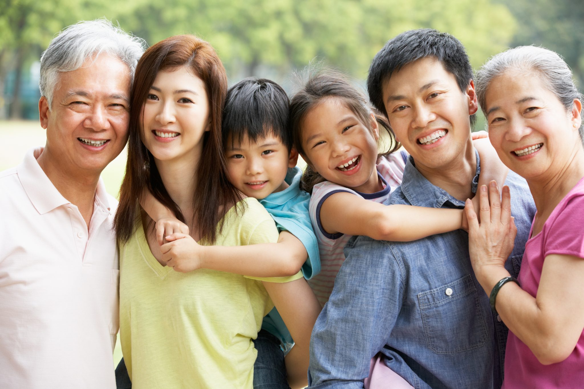 Portrait Of Multi-Generation Chinese Family Relaxing In Park Together